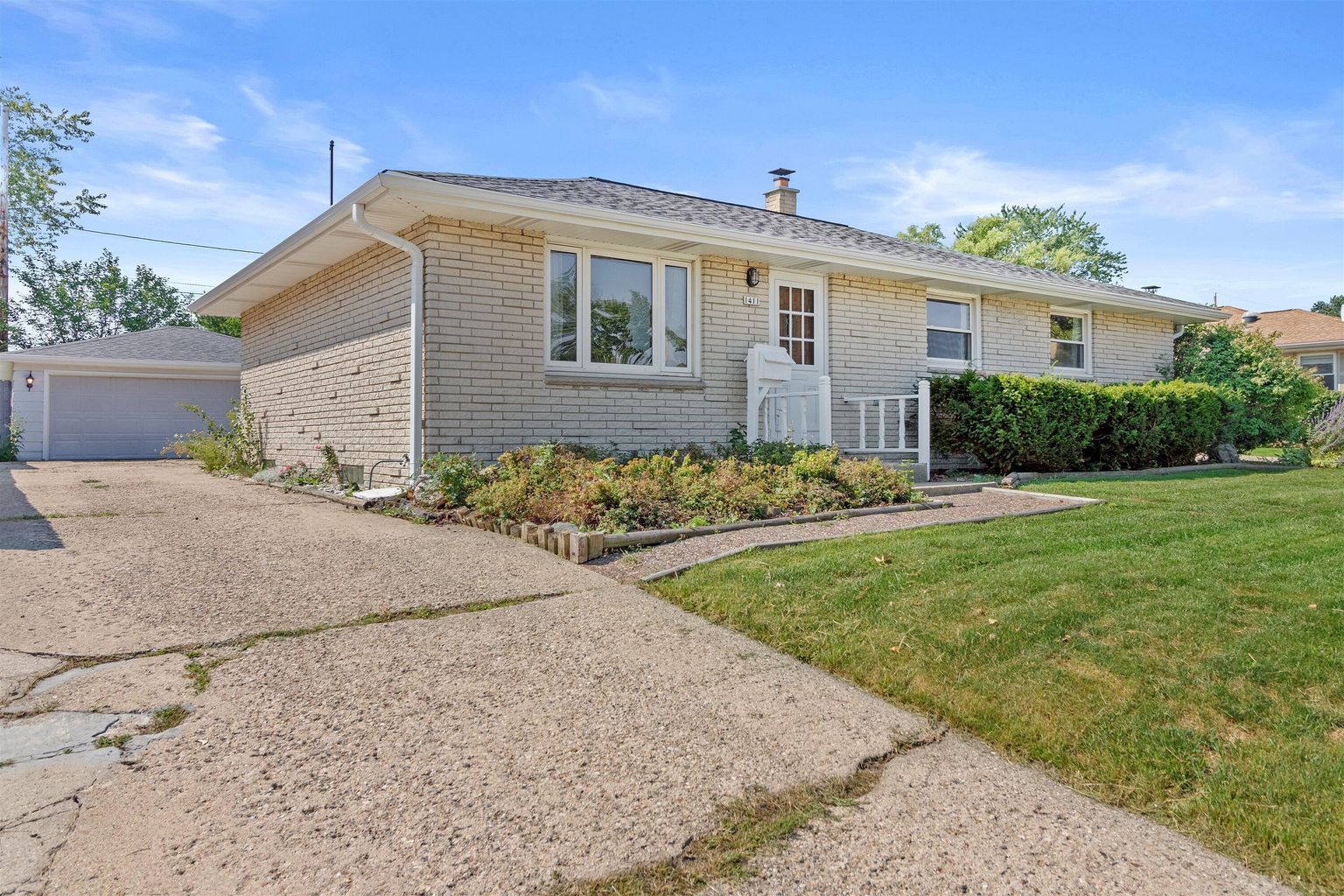 The front of a brookfield house with a driveway and a garage.
