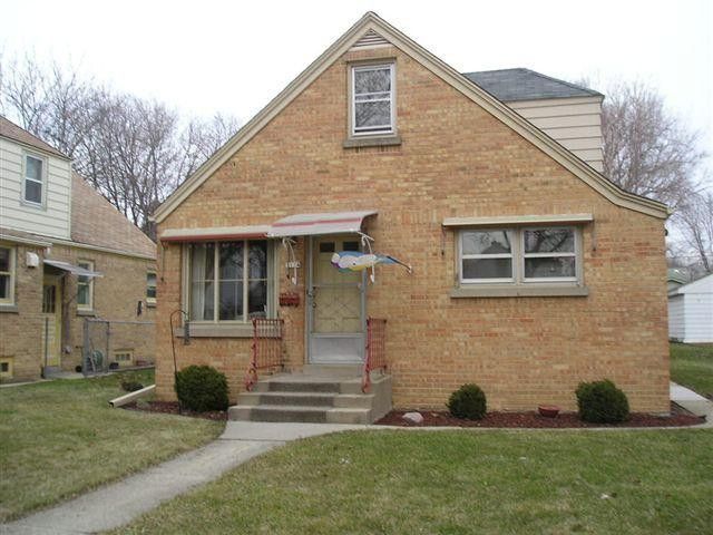 A small menomonee falls brick house with a fish on the front porch