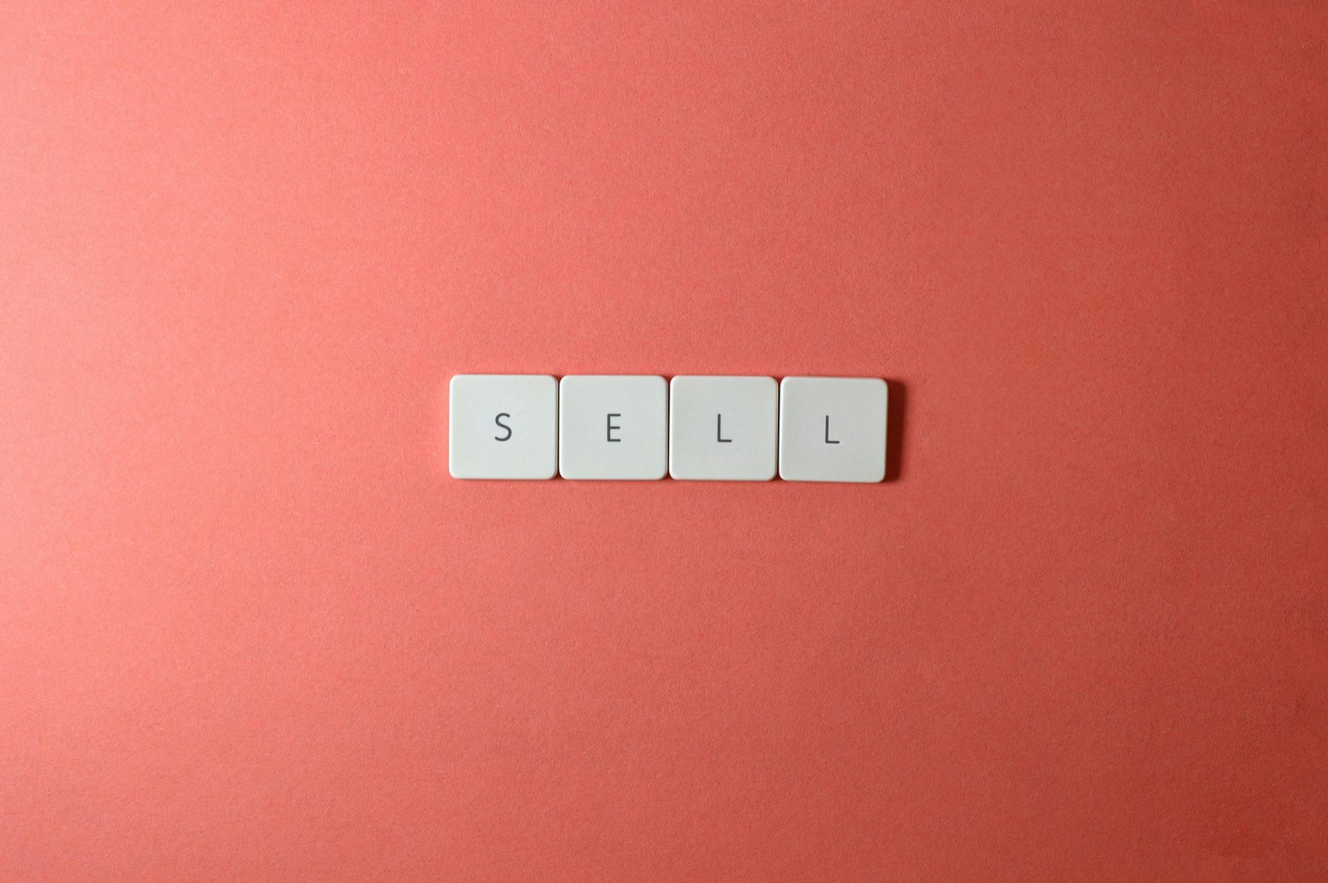 Four white square tiles spelling 
