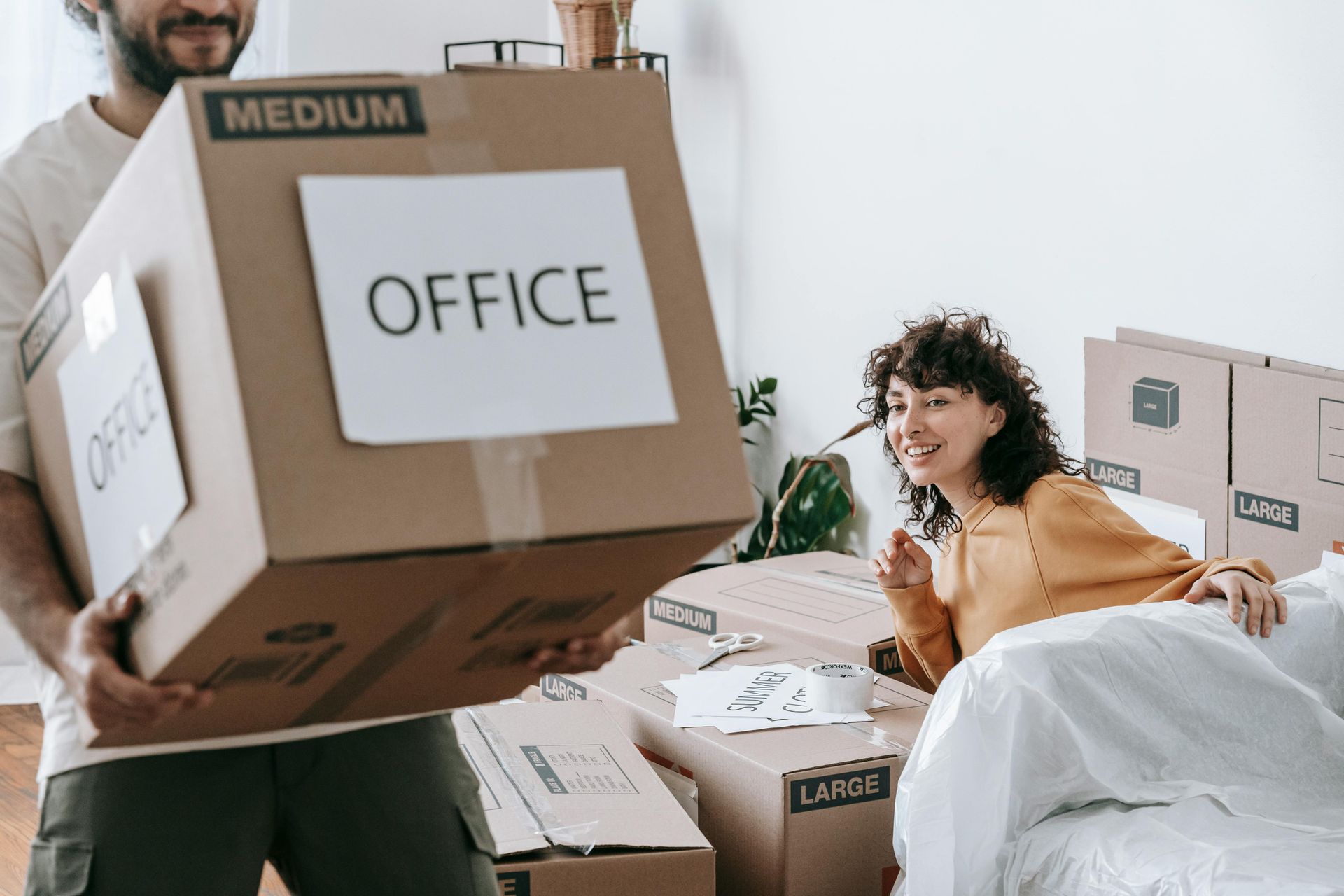 A person carries a cardboard box labeled