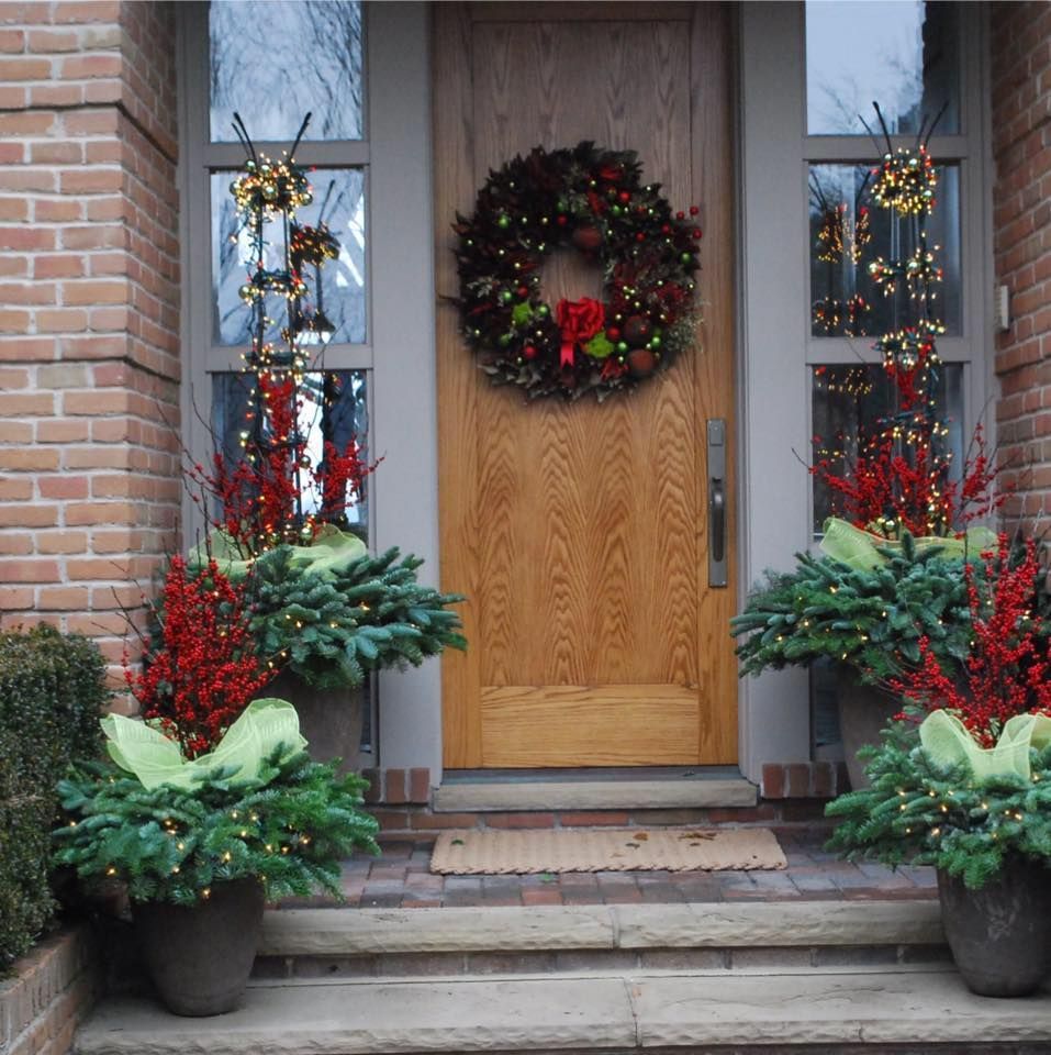 Festively decorated front porch with wreath, red bows, and potted evergreen arrangements
