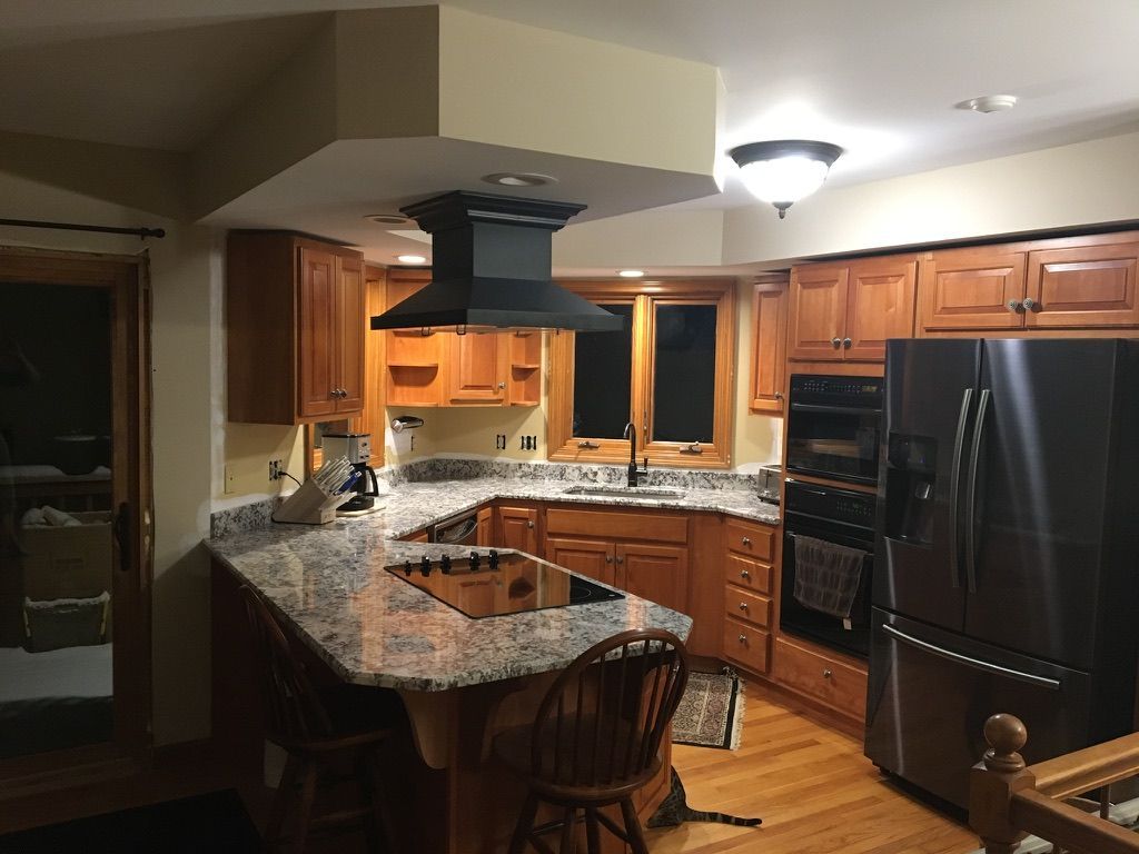 A kitchen with stainless steel appliances and wooden cabinets