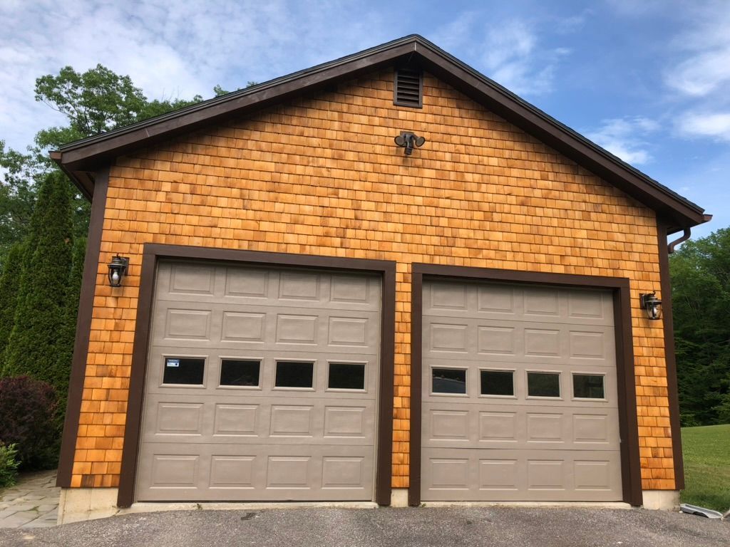 A garage with two garage doors and a roof