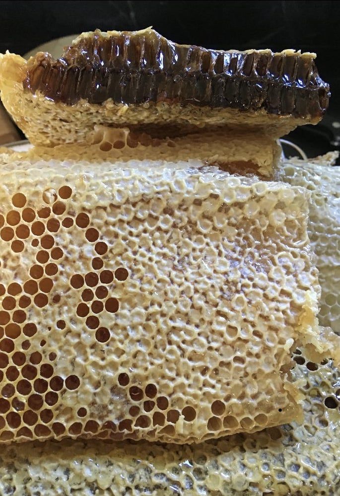 A close up of a piece of honeycomb with honey on it