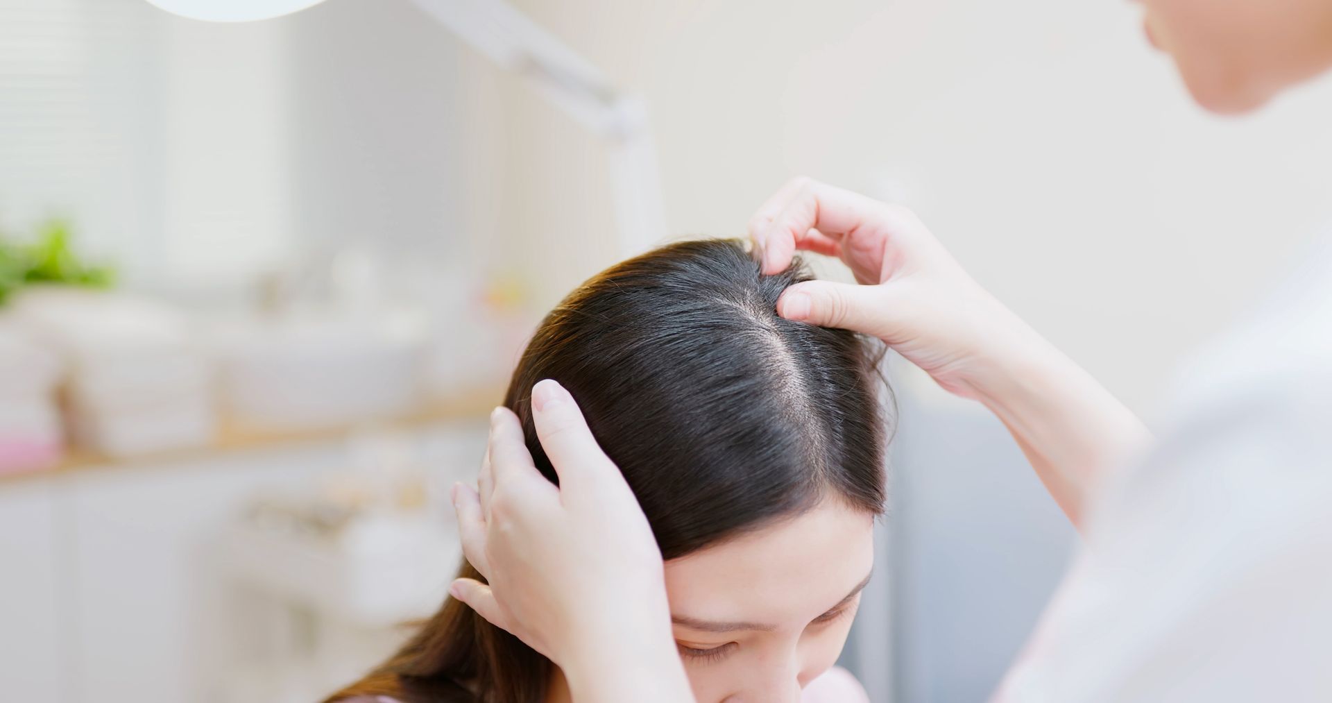 Woman with thinning hair being examined by another person. Woman with thinning hair being examined by another person.