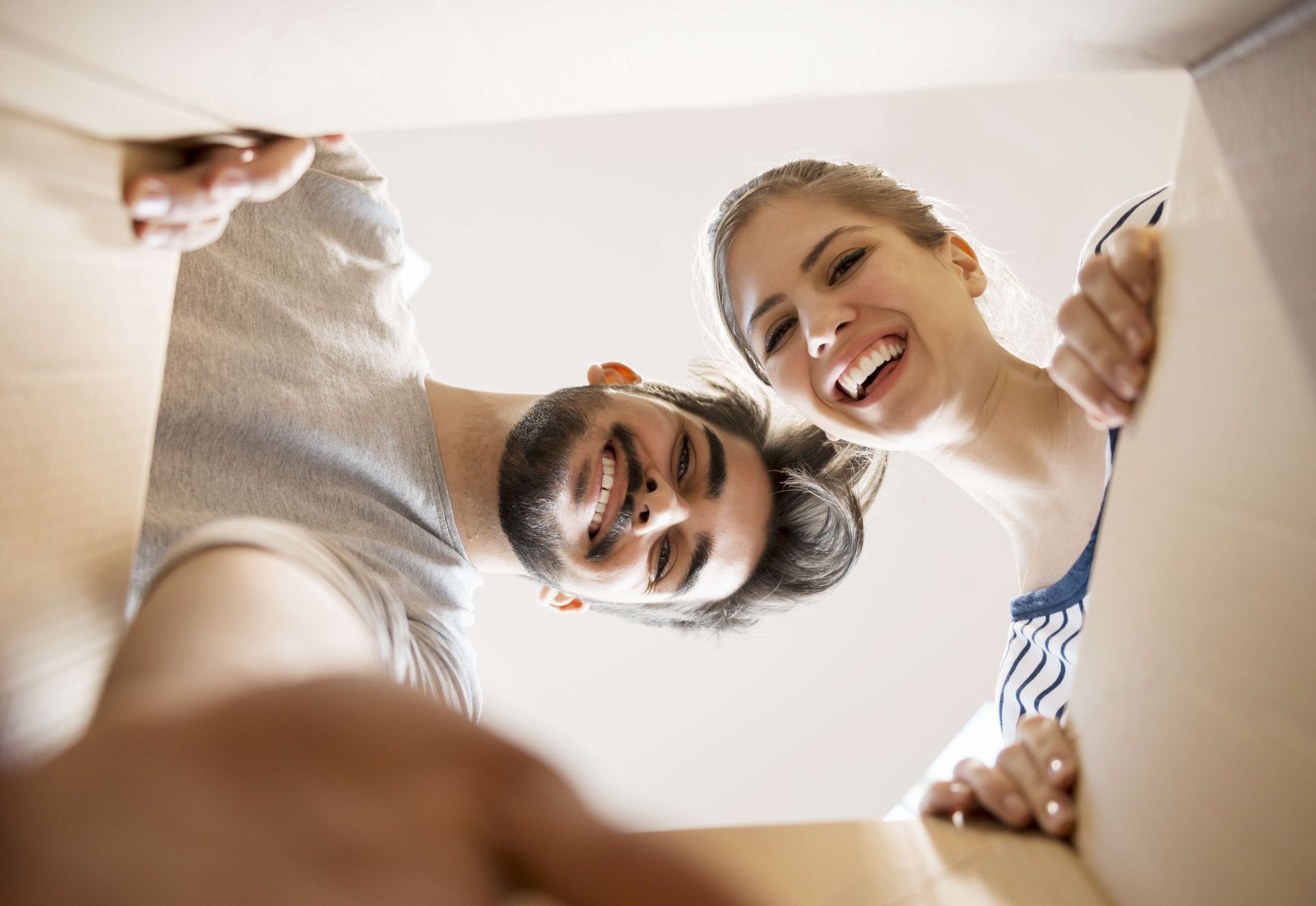 a man and a woman are looking into a box and smiling