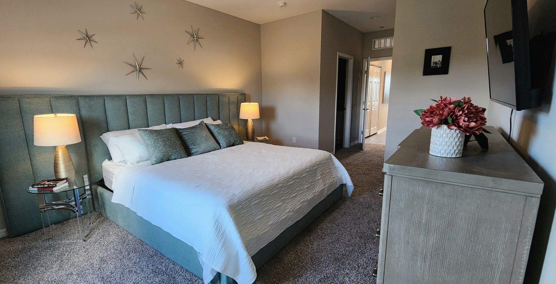 a bedroom with a king size bed and a dresser at Whitney Place Apartments in Clearwater, FL.