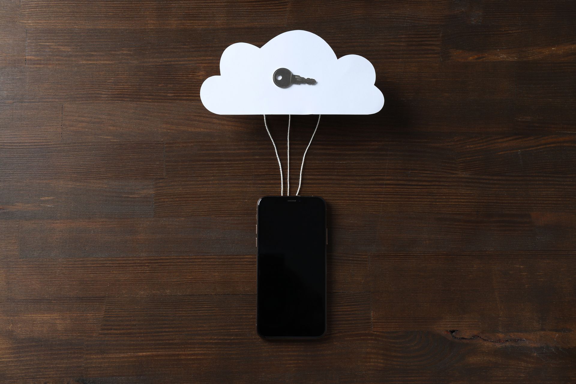 Black smartphone with a paper cloud on a dark background