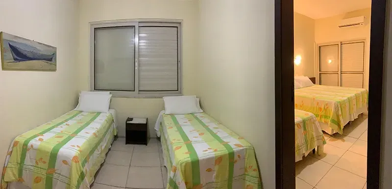 Cabanas de madeira com varandas e passarelas sombreadas em um ambiente tropical.