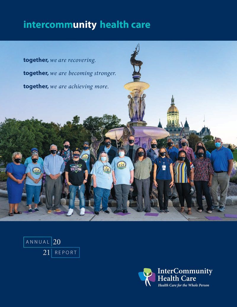A group of people standing together in front of a fountain and a government building, with the InterCommunity logo above.