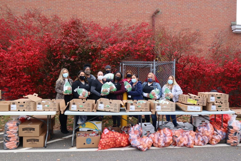Group of people holding food items and smiling