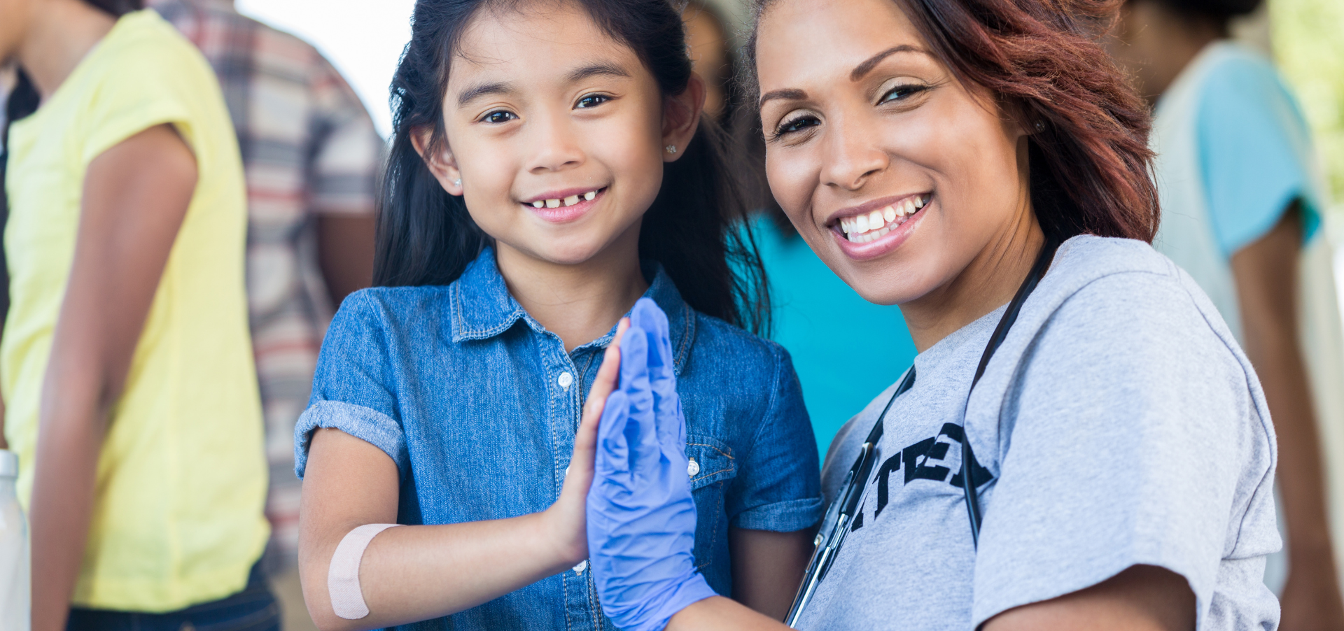 A girl and a doctor smile and touch hands.