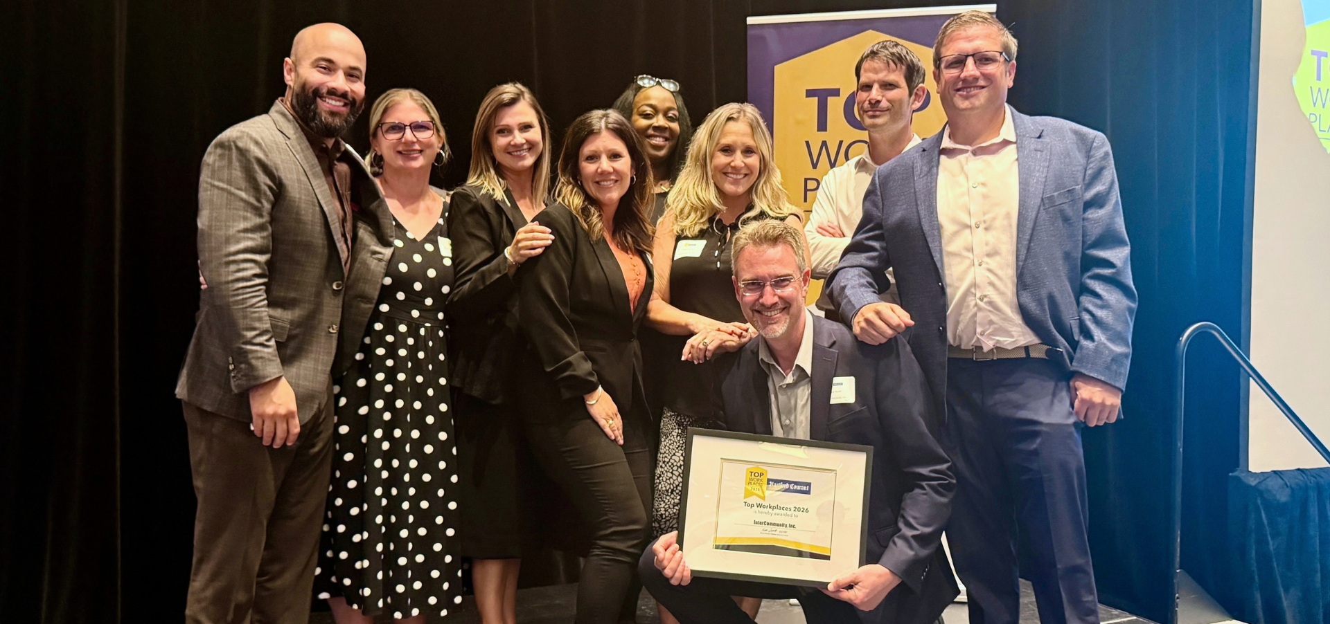 InterCommunity staff pose at the awards ceremony with the agency's 2026 Top Workplace award.
