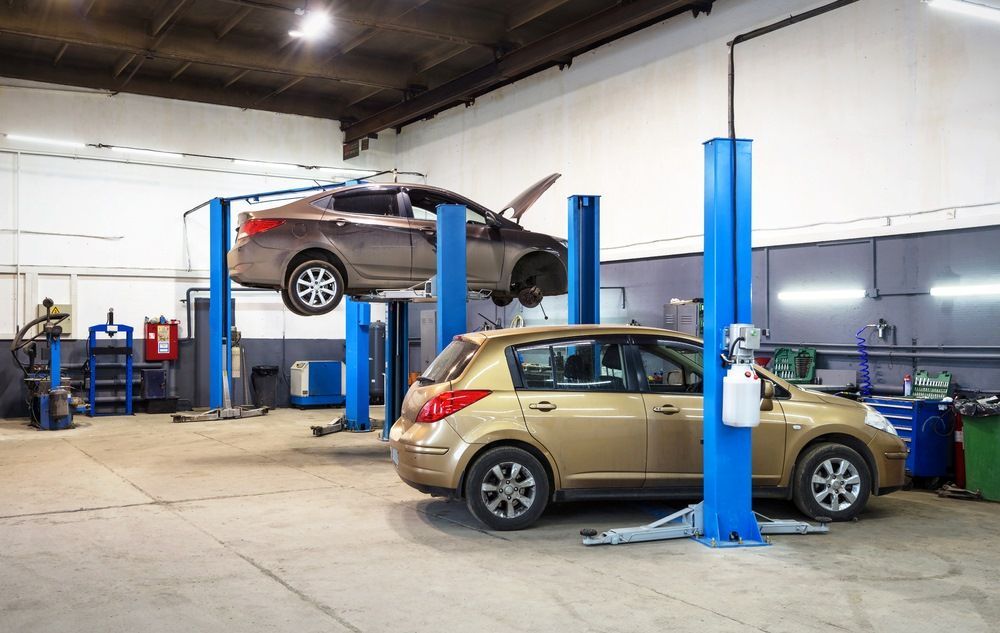 A Car Is Sitting On A Lift In A Garage — Tuned Suspension & Mechanic in Parkes, NSW
