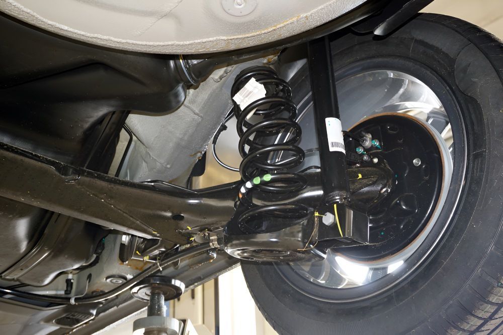 The Underside Of A Car With A Shock Absorber And A Tire — Tuned Suspension & Mechanical in Parkes, NSW