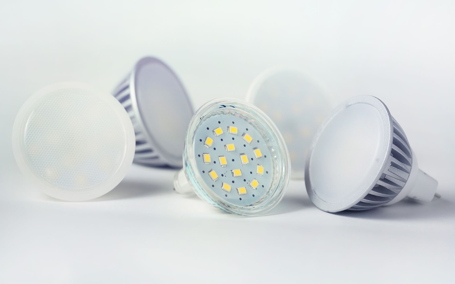 Un groupe de différents types de lumières LED sont posés les uns sur les autres sur une surface blanche.