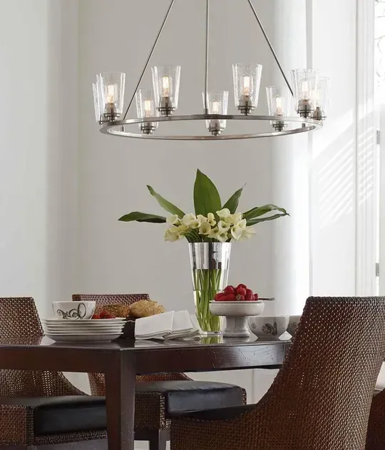 A dining room table with a vase of flowers on it