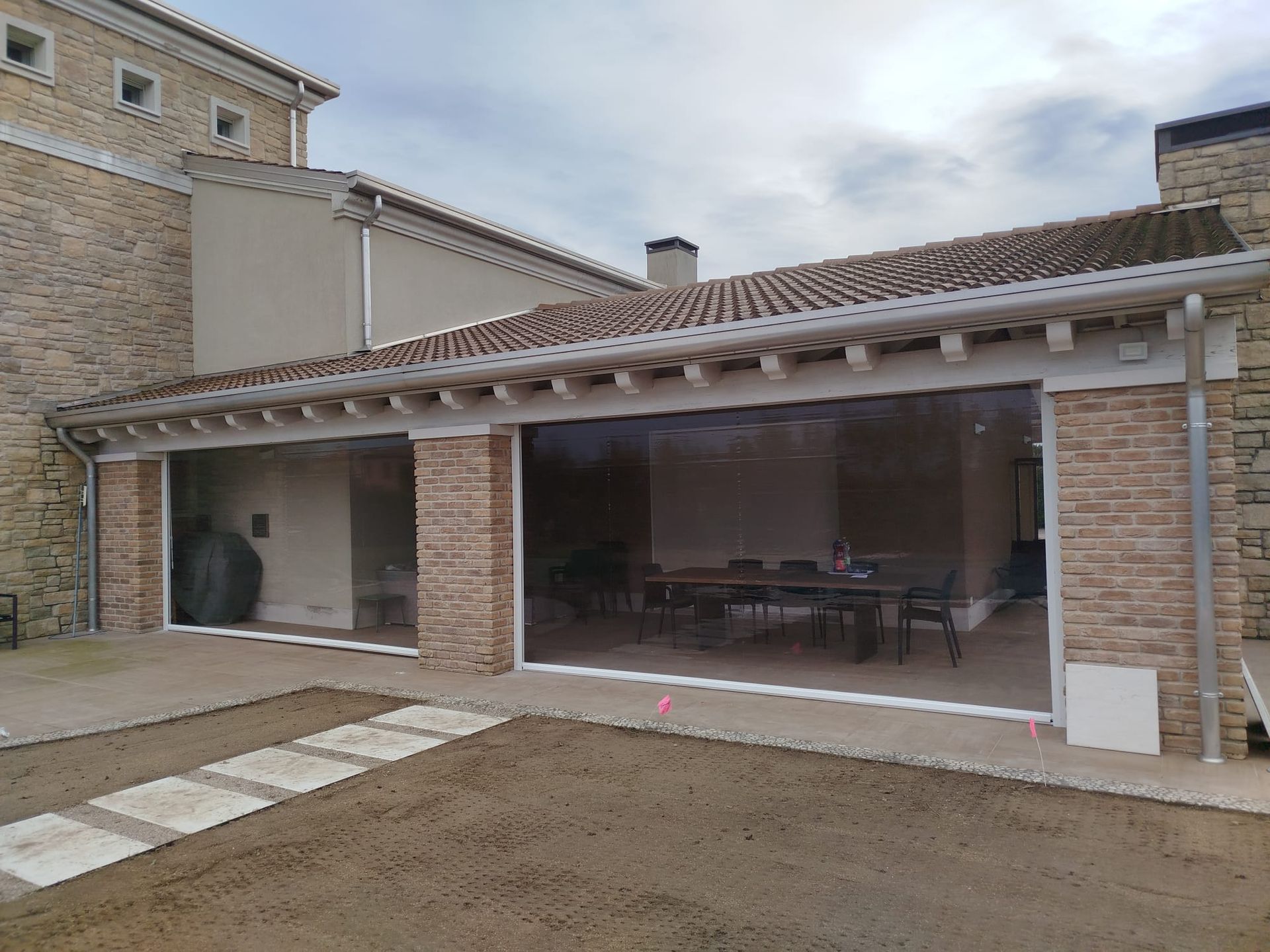 Una grande casa con molte finestre e un patio.