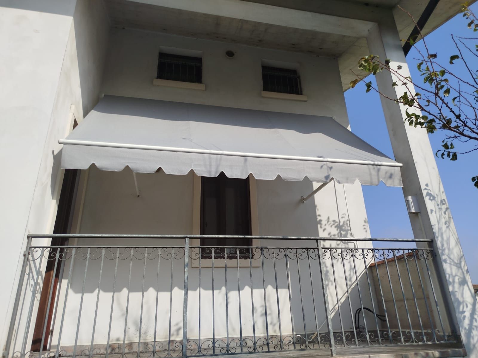 Un balcone con una tenda bianca sopra