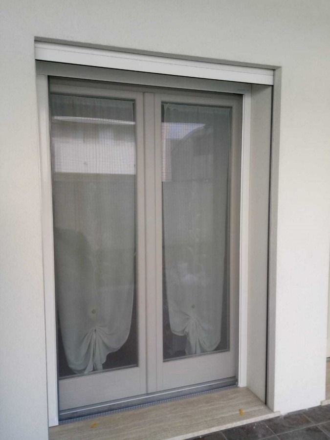 Una porta bianca con una tenda bianca.