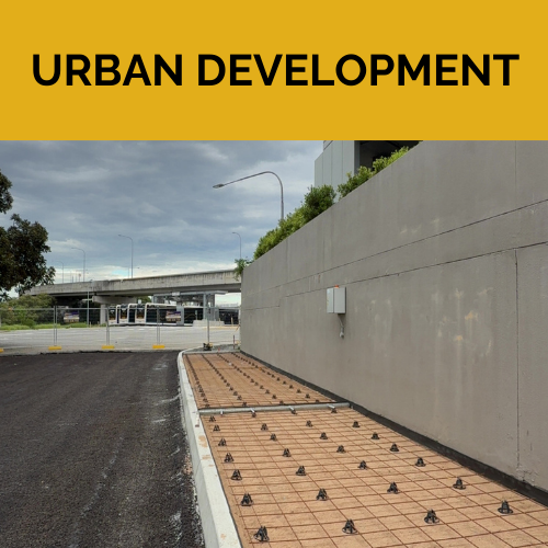 A walkway ready to be filled with concrete eading to a building with a bridge in the background.