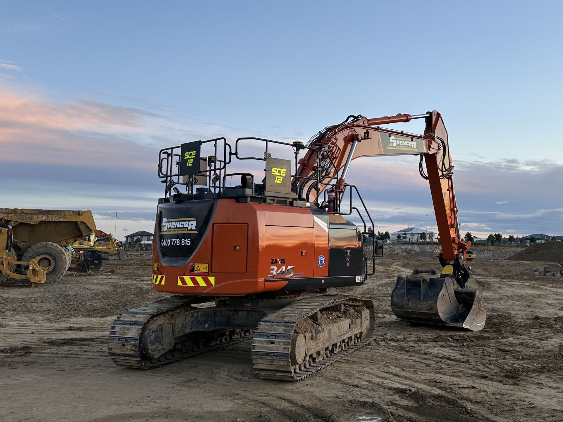 large excavator parked up for the evening on a dirt slab