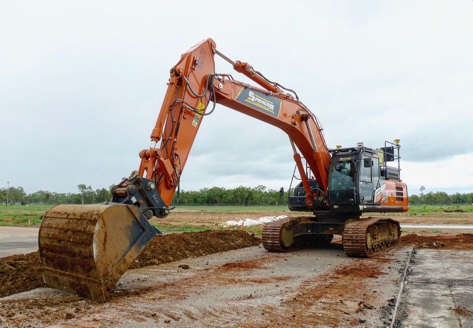 A large Spencer civil & earthworks excavator is scraping the ground to flatten it.