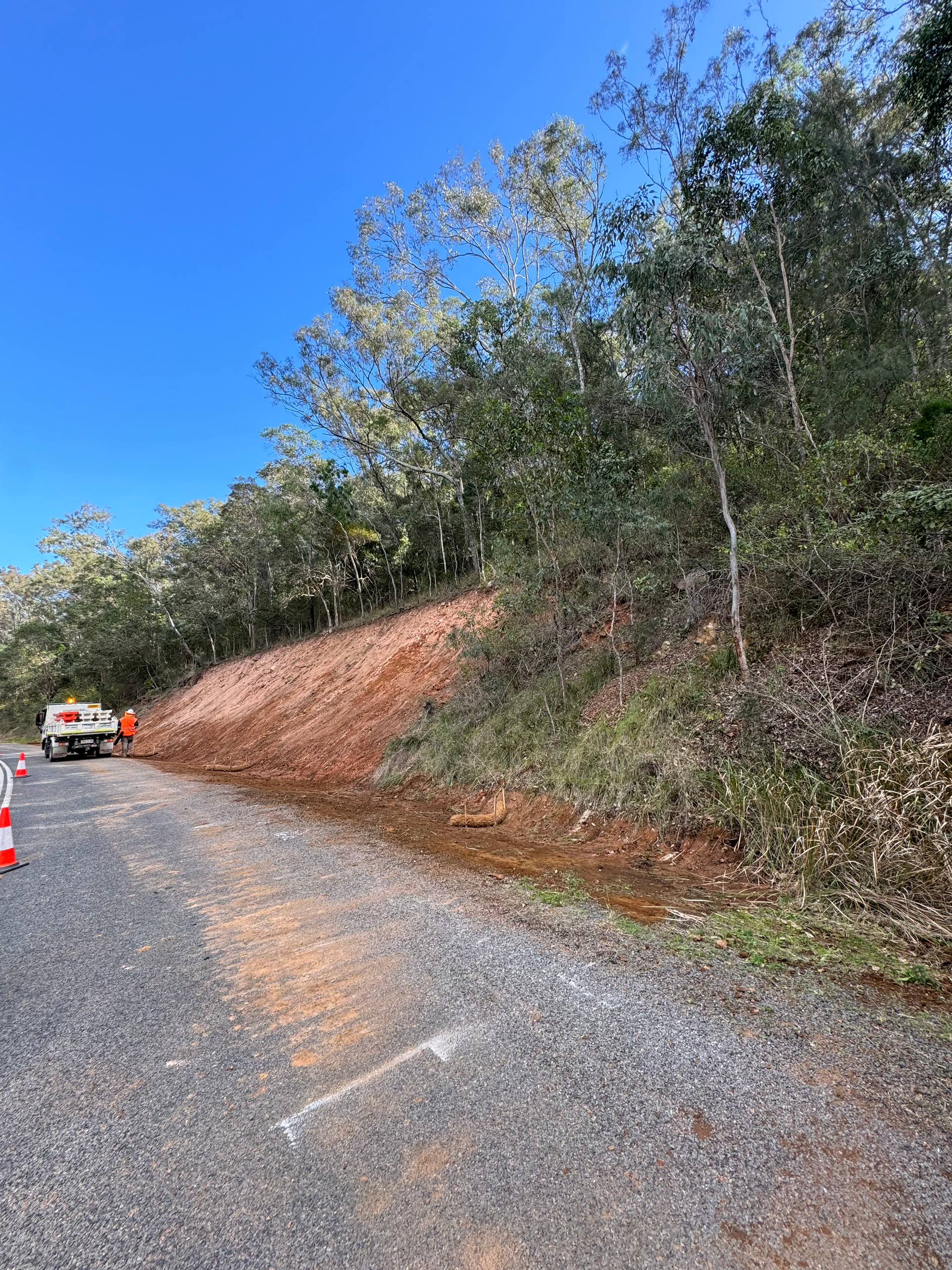A spencer civil & earthworks ute is parked next to a hill which is being repaired after experiencing a slip.