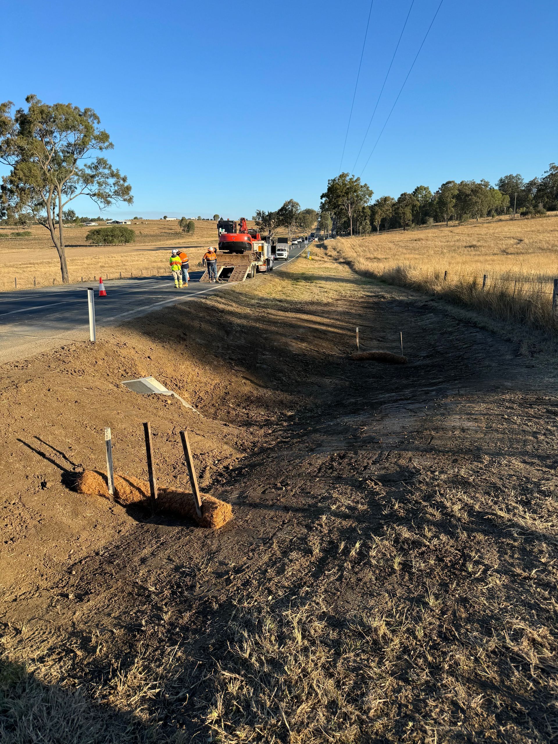 A photo of the finished stormwater drain and ditch on a roadside.