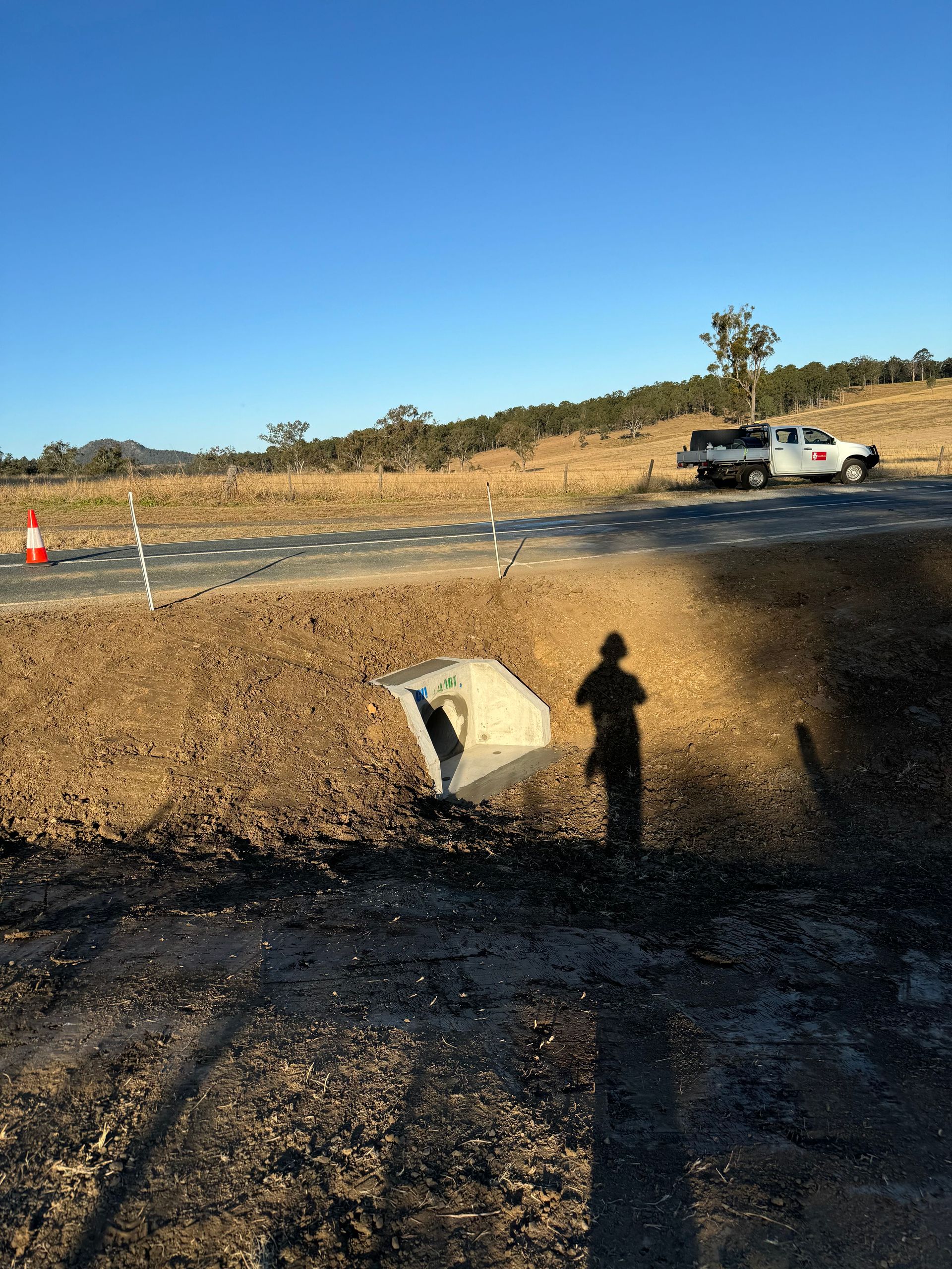 A photo of a completed stormwater drain next to a road.