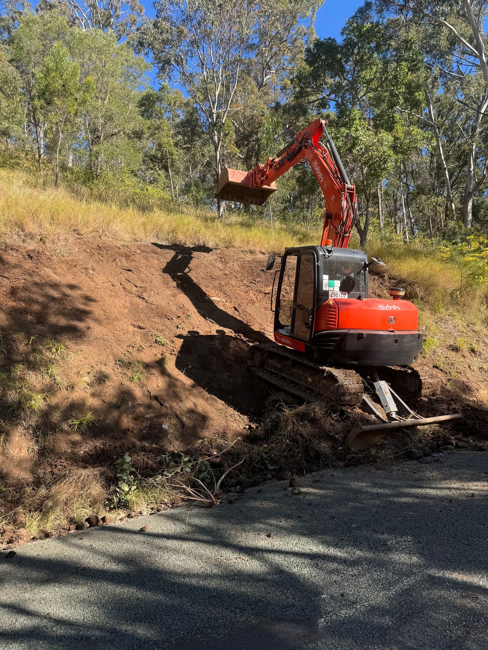 A red spencer civil & earthworks excavator working on hillside erosion repairs.
