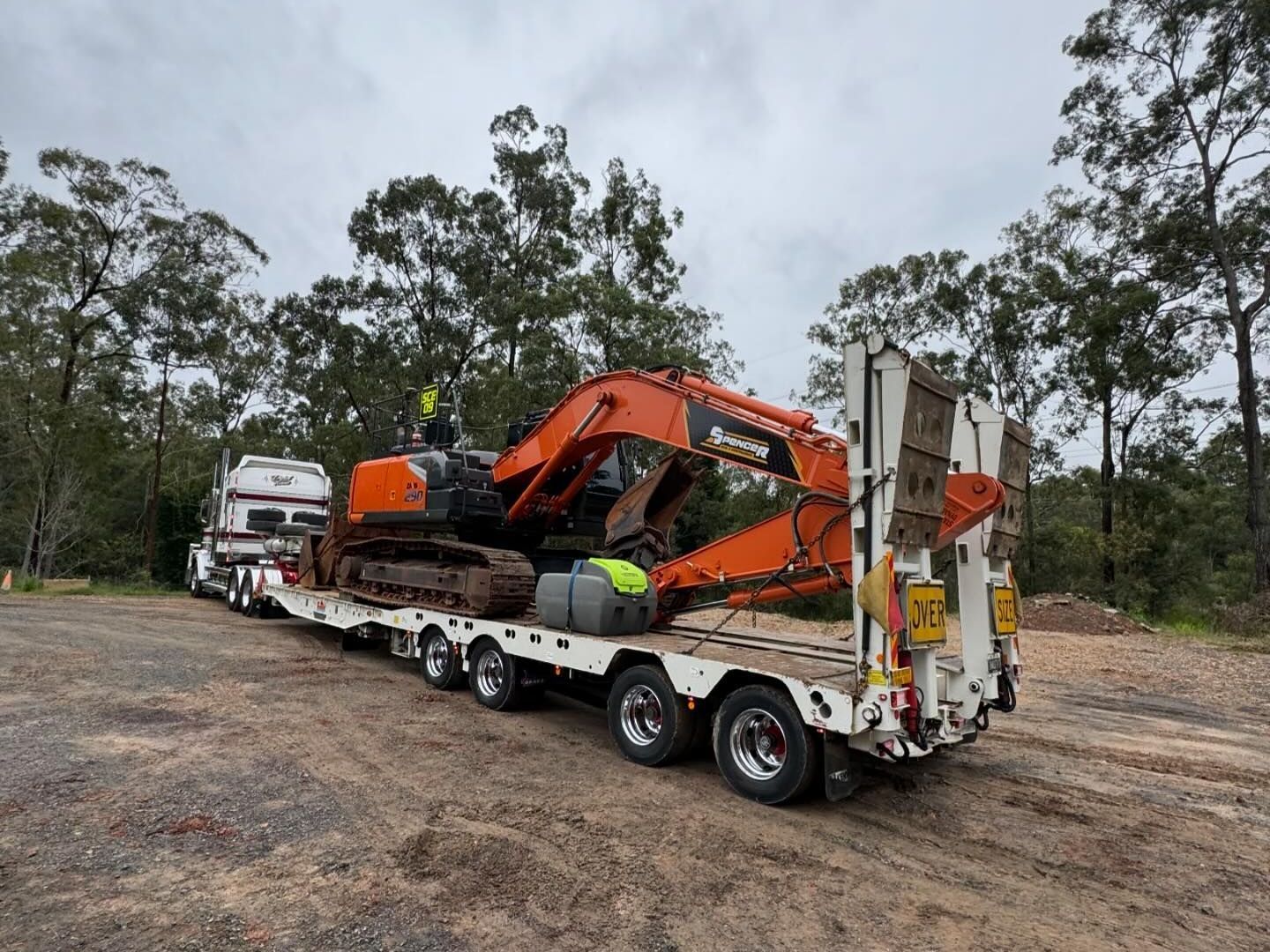 A large Spencer civil & earthworks excavator is being transported on a truck, a great example of our haulage services.