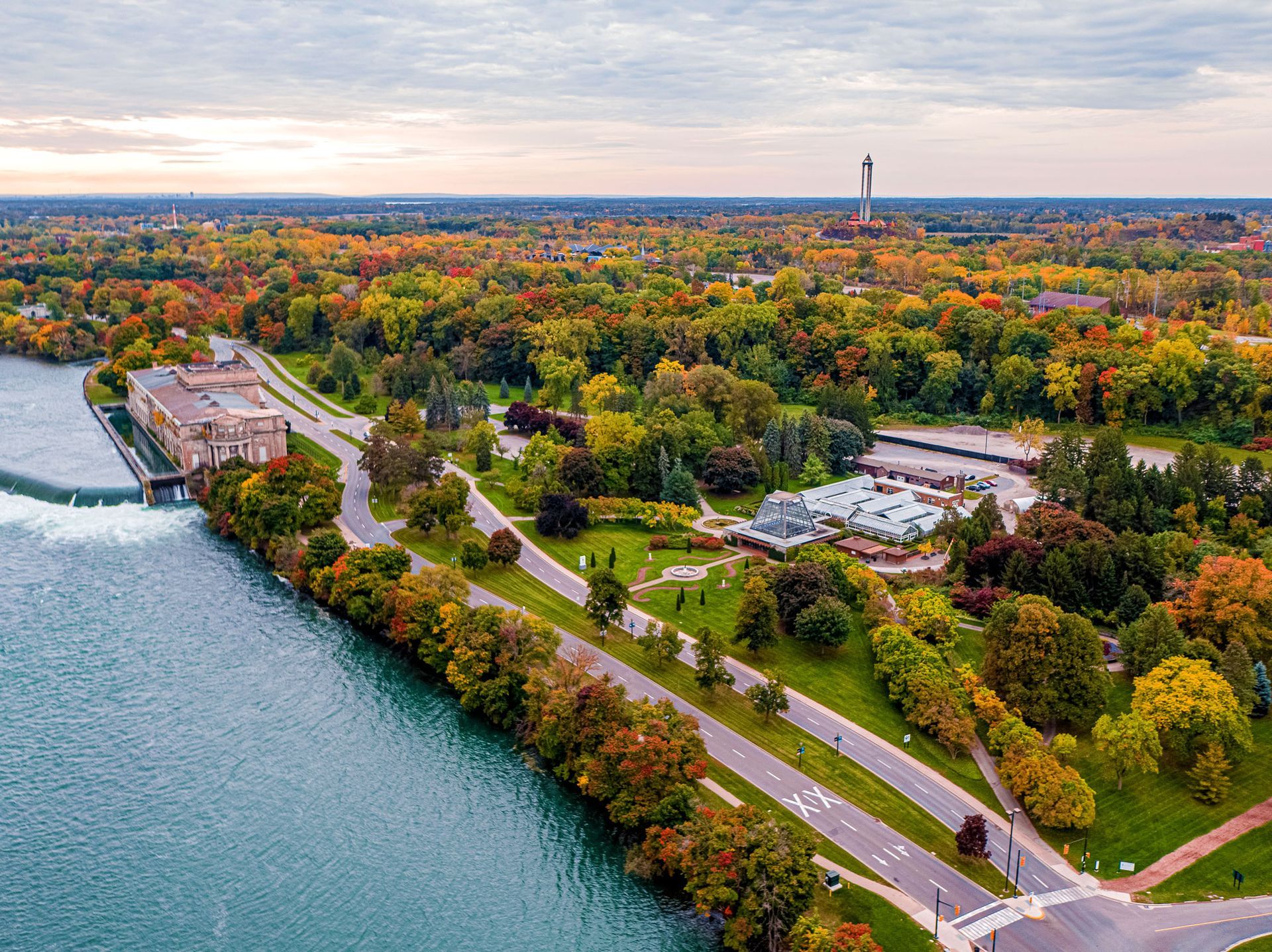 An aerial view of a park surrounded by trees and a body of water.