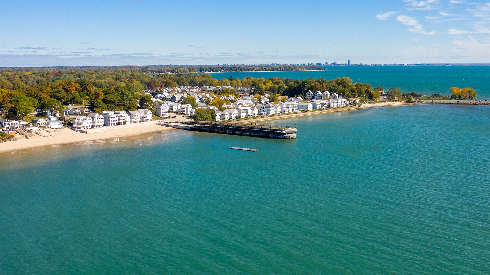 An aerial view of a small town on the shore of a large body of water.