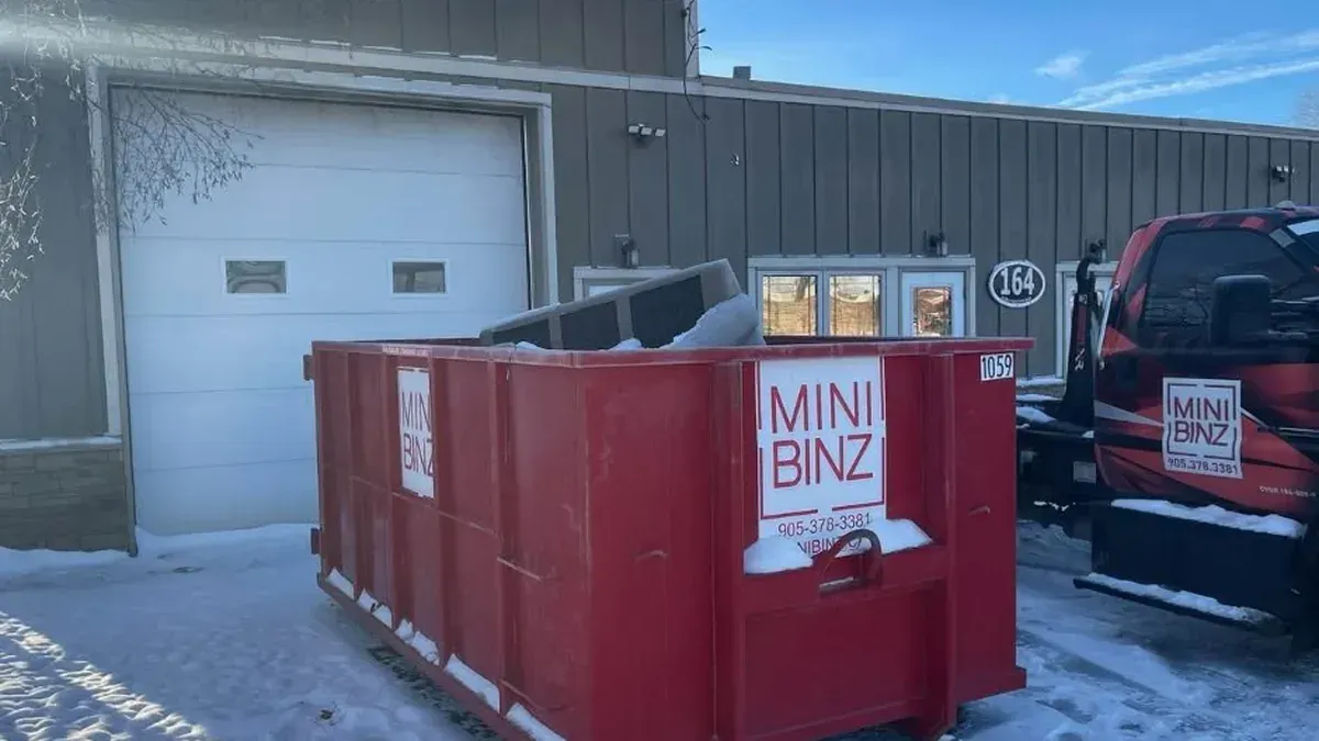 Mini Binz red bin rental container outside facility in St. Catharines Ontario in winter