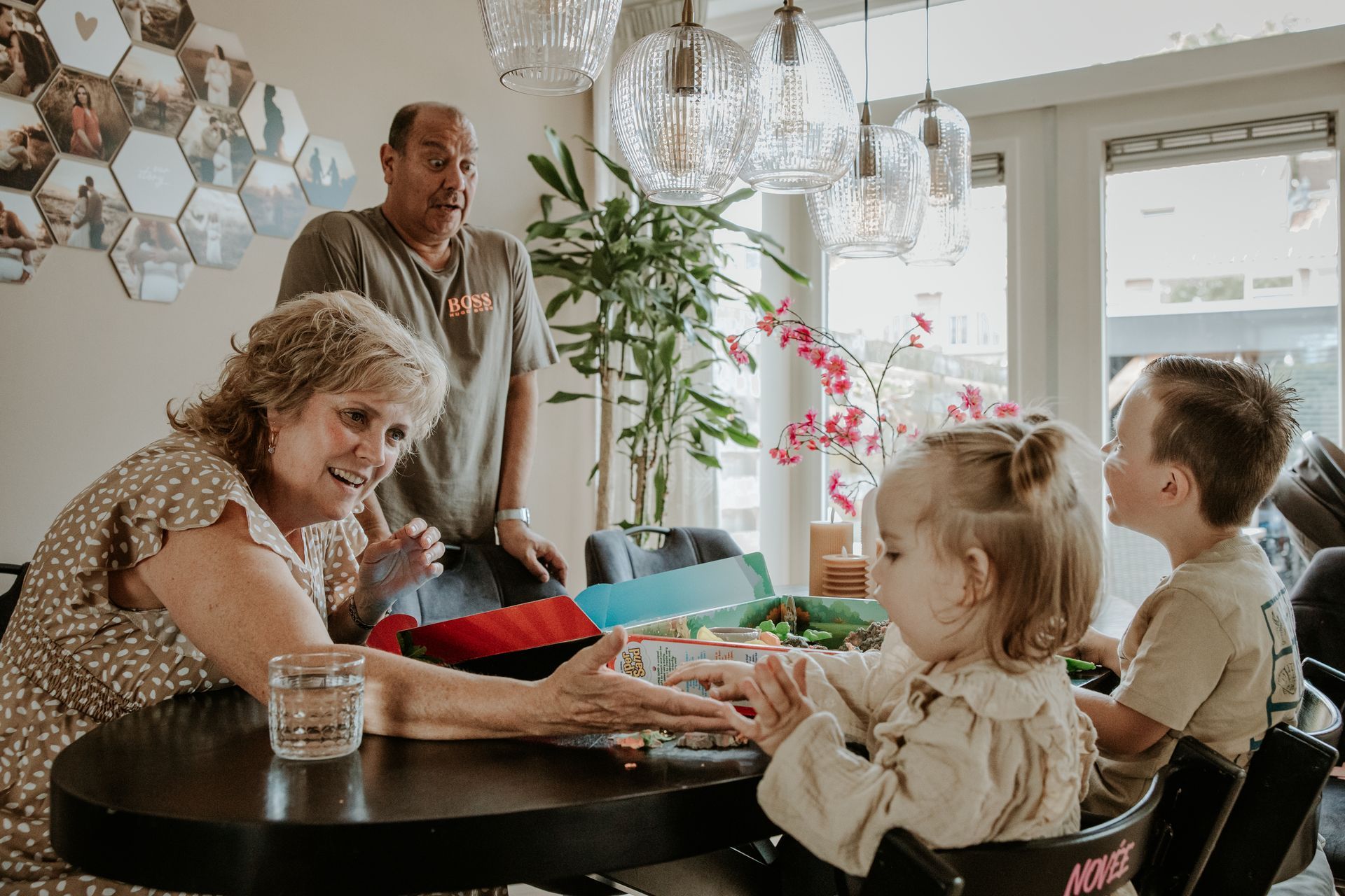 Opa en oma spelen samen met kleinkinderen een spelletje aan tafel tijdens moment thuis