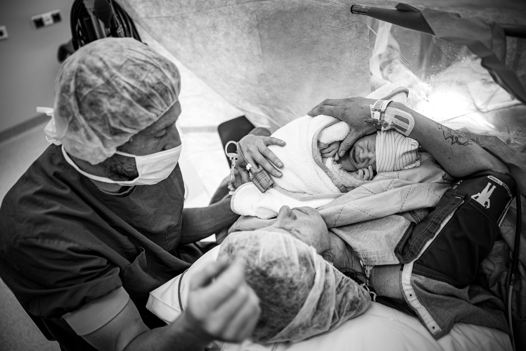 Pasgeboren baby ligt na een keizersnede in het ziekenhuis bij de ouders tijdens de eerste ontmoeting.