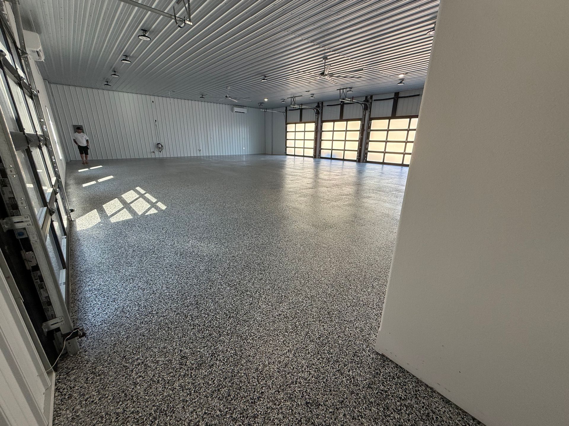 Modern foyer with marble floors, floating staircase, glass railing, and tall windows