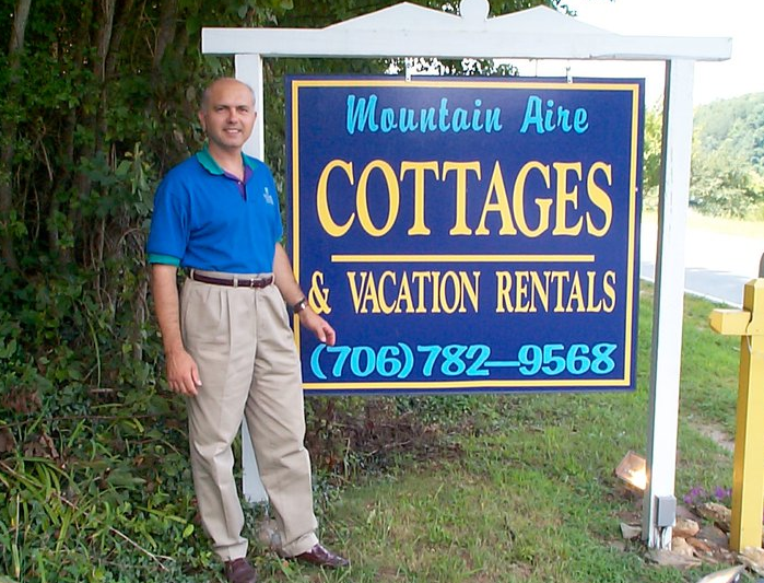 Man Standing Next to a Street Sign
