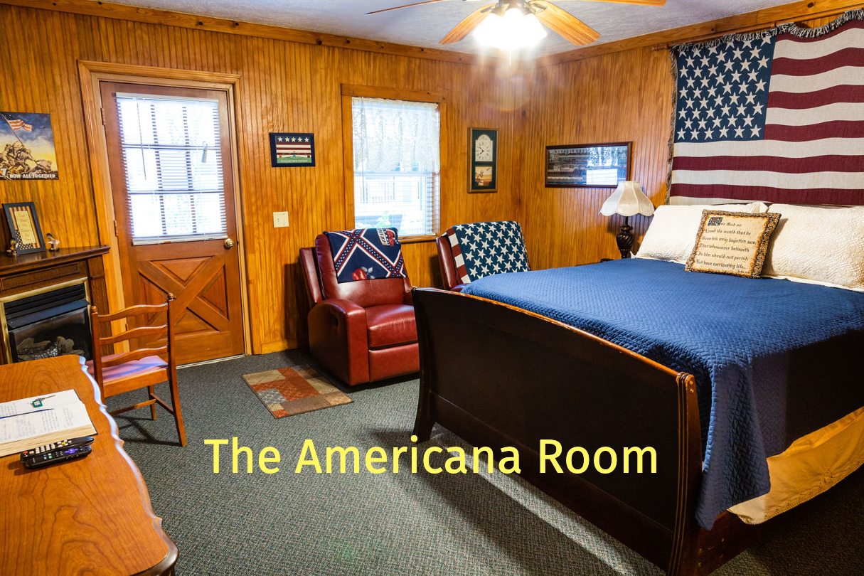 A bedroom with wood paneling, a bed under an American flag, and a red recliner chair.