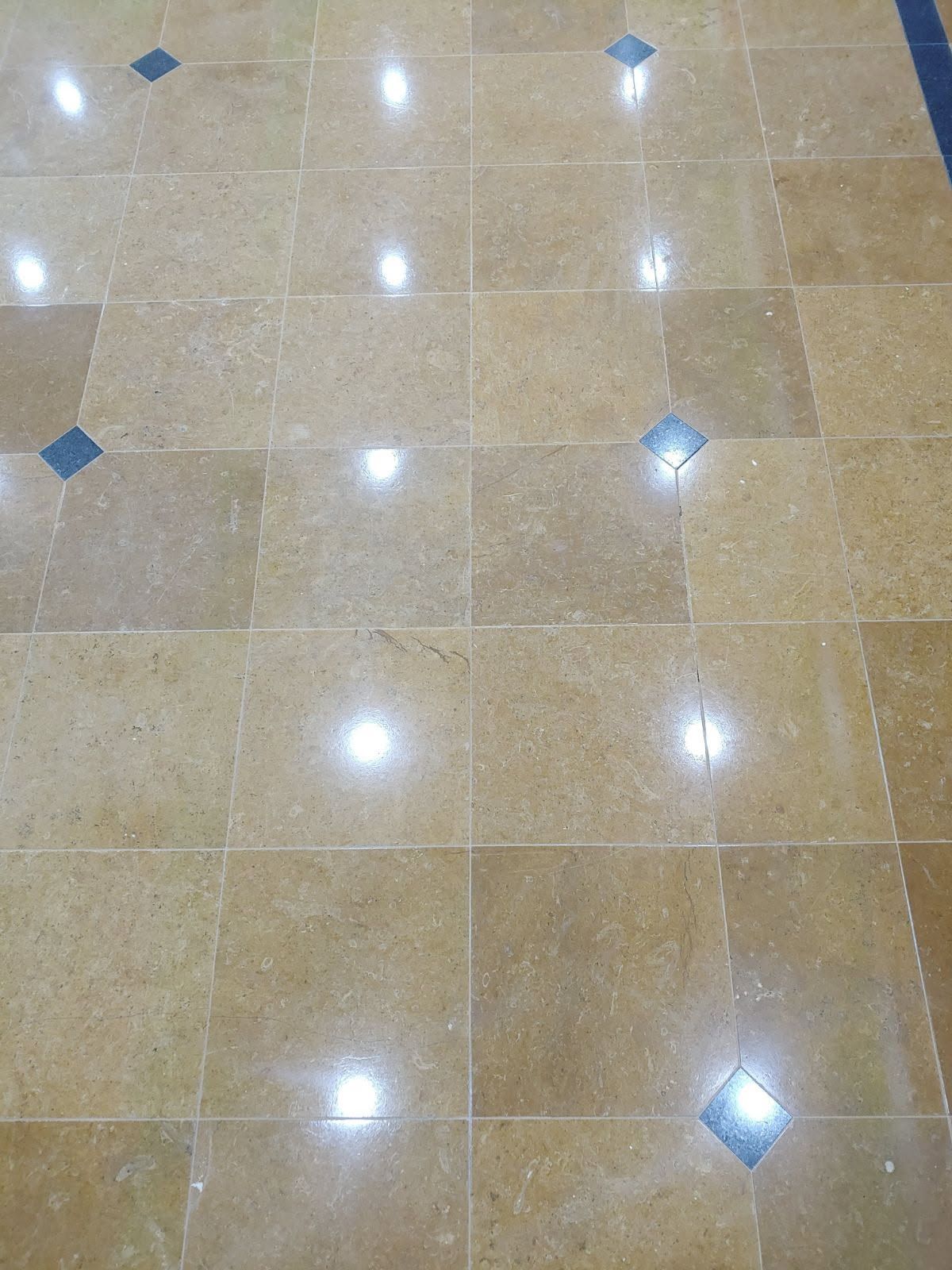 Tan tiled floor with blue diamond accents reflecting bright light.