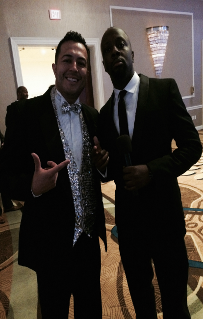 Two men in suits and bow ties pose for a picture