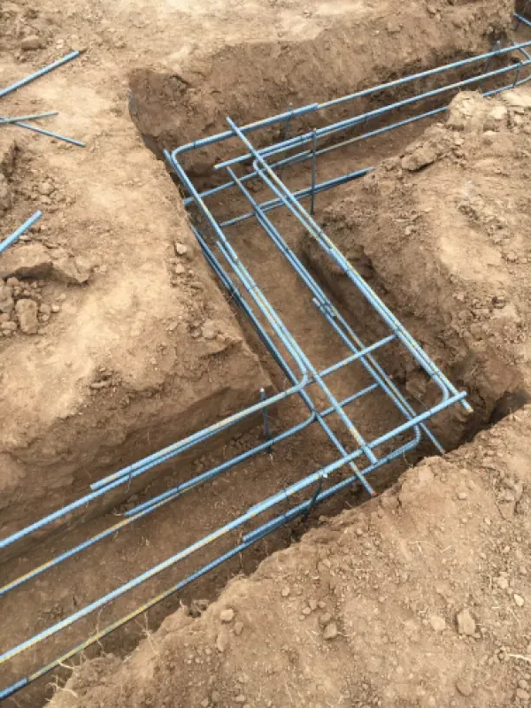 Reinforcement bars arranged in a trench, prepared for a concrete foundation.