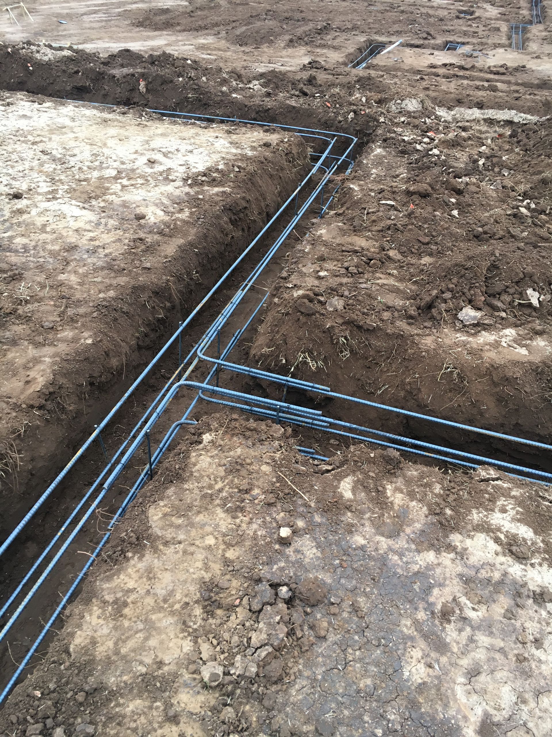 Rebar framework in trenches, prepared for concrete foundation.