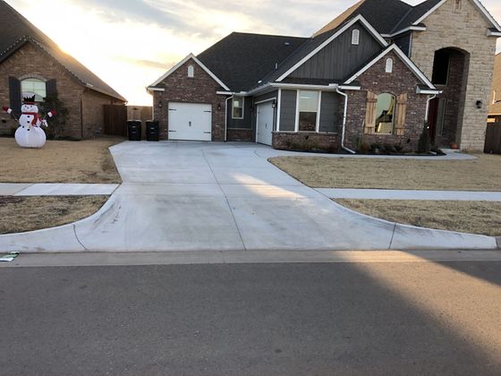 A house with a driveway. A snowman and sun are visible.