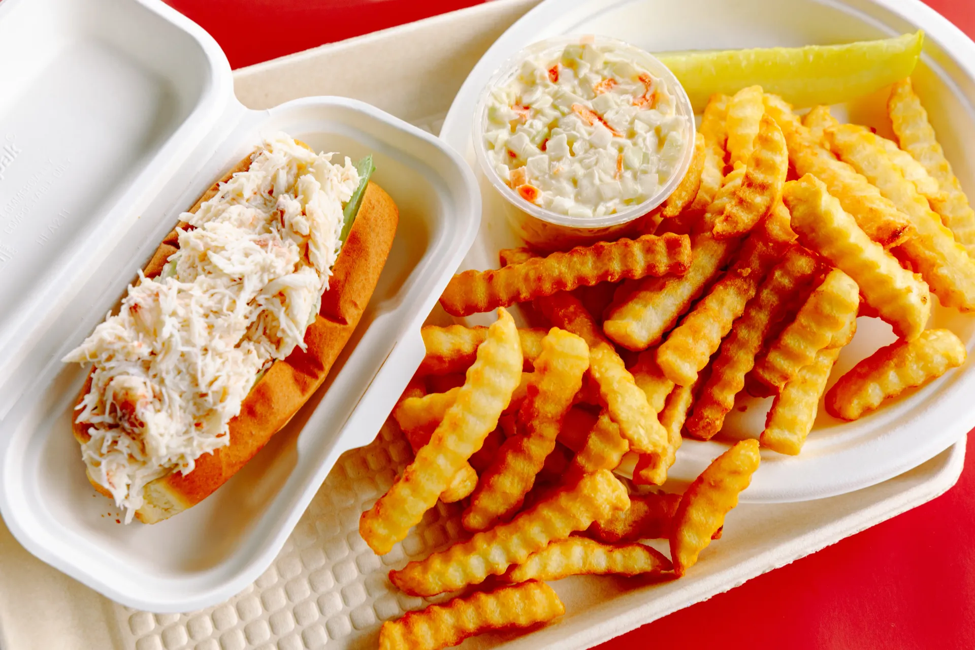 Crabmeat roll, french fries, and cole slaw beautifully prepared at Ken's Seafood Restaurant.