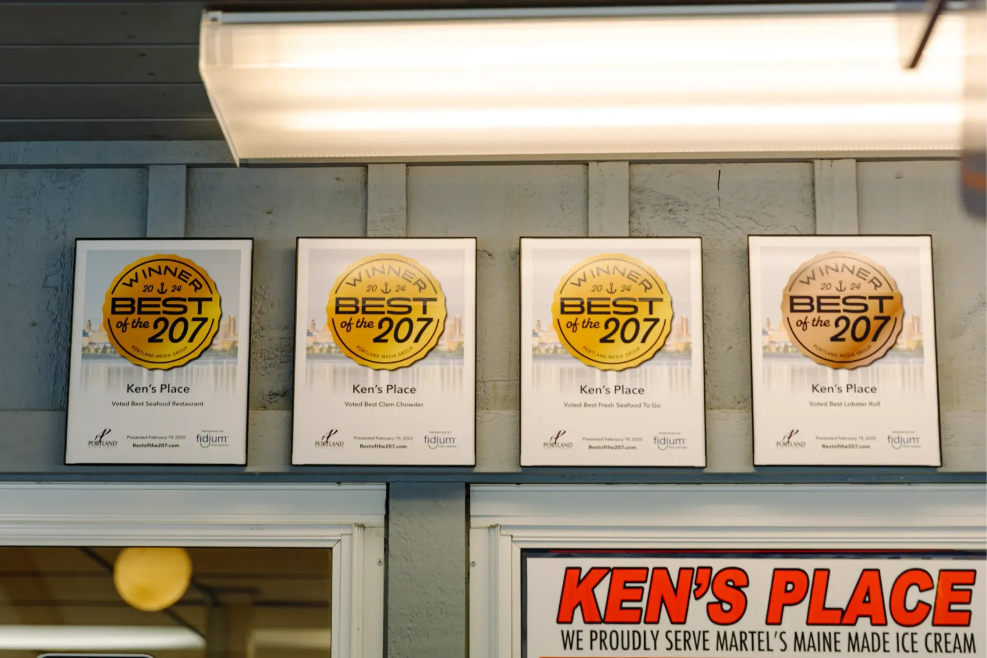 4 plaques on the wall showing they won the Gold  in The Best of 207 for best chowder, best bloody mary, lobster, and lobster roll.