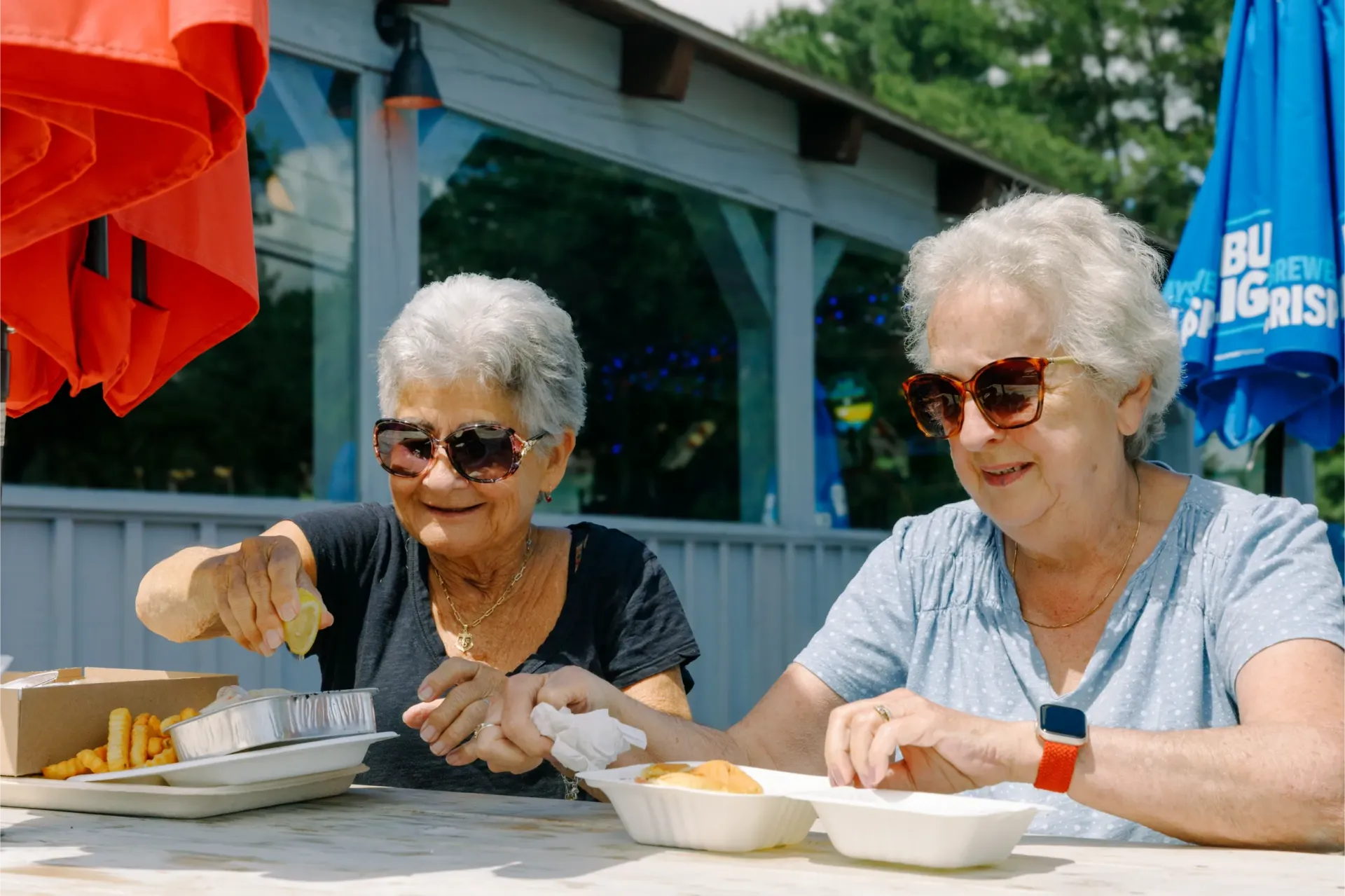 two ladies eating seafood outside at Kens Seafood Restaurant