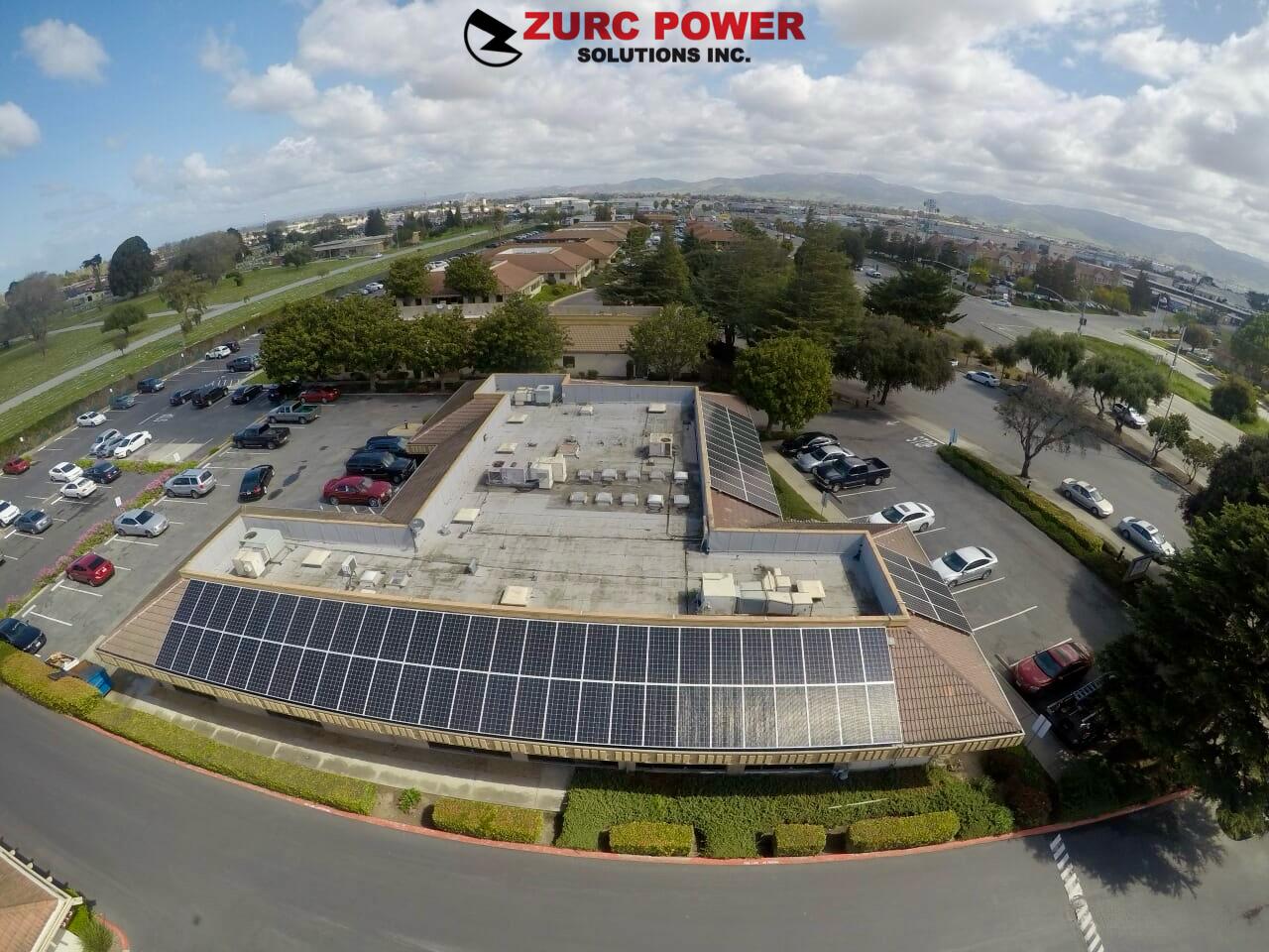 An aerial view of a building with solar panels on the roof