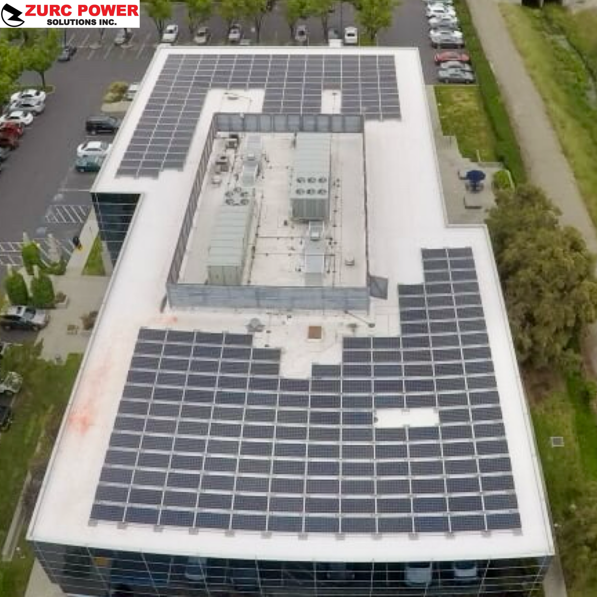 An aerial view of a large building with solar panels on the roof.